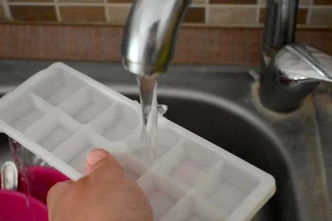 Filling an ice cube tray with water Stock Photos