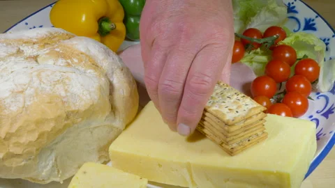 Filling a large serving plate with cheese, ham and salad items. Stock-Footage 135306633