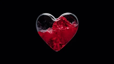 Filling liquid inside glass heart shape in center of black background Stock Footage 327572802