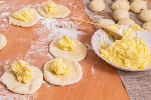 The filling of mashed potatoes lies on small dough cakes. Homemade baking Stock Photos
