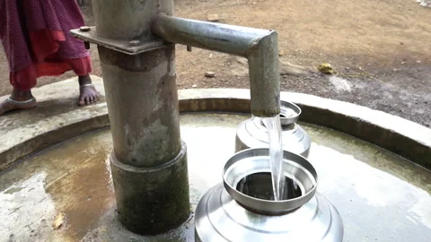 Filling metal container with drinking water from hand pump, India Vidéo 165228684