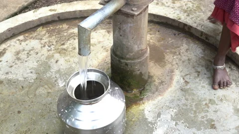 Filling metal container with drinking water from hand pump, India Vidéo 165229961