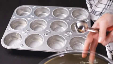 Filling metal muffin pan with cornbread batter. Stock Footage 96355664