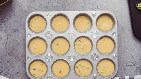 Filling metal muffin pan with cornbread batter Stock Footage 97152465