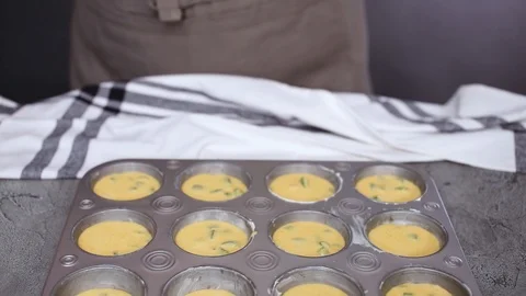 Filling metal muffin pan with cornbread batter Stock Footage 97153144