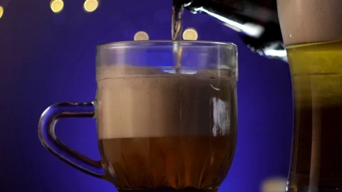 Filling mug of lager cold beer with huge beer foam from the bottle Stock Footage 129651979