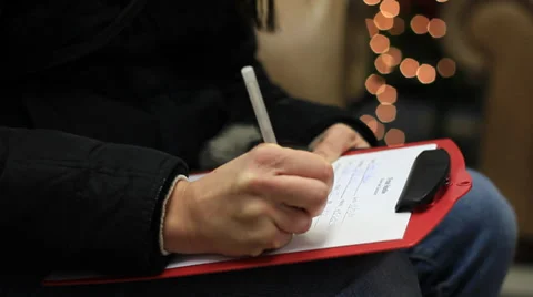 Filling out paper work on a clipboard at Christmas time. Video stock 33689174