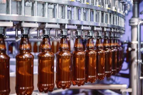 Filling plastic bottles with various drinks on an automatic filling machine Stock Photos
