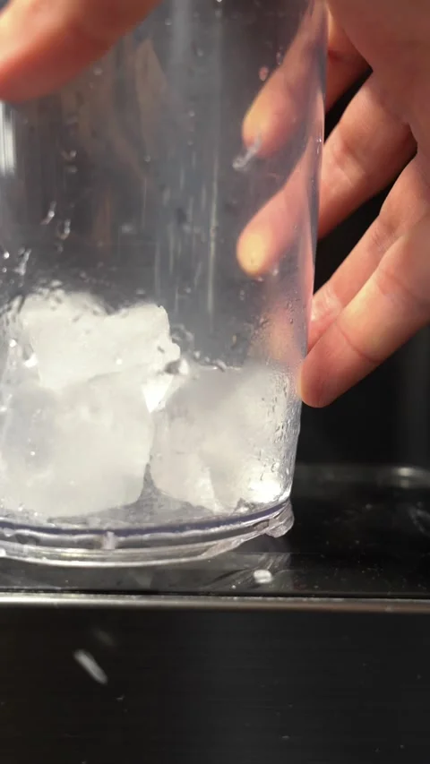 Filling plastic cup with ice cubes from refrigerator dispenser Stock Footage 312945438