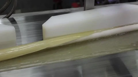 The filling for the production of caramel sweets gets into the hot caramel Stock Footage 130395044