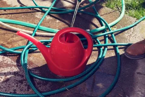 Filling red water can wirh water Stock Photos