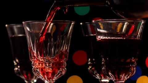 Filling a round of glasses of red wine served in elegant fluted crystal glasses. Stock Footage 100975544