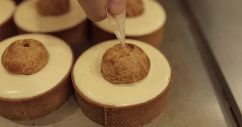 Filling small eclairs with cream using a culinary syringe Stock Footage 254813122