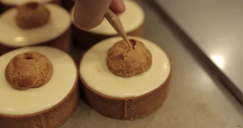 Filling small eclairs with cream using a culinary syringe Stock Footage 254813250