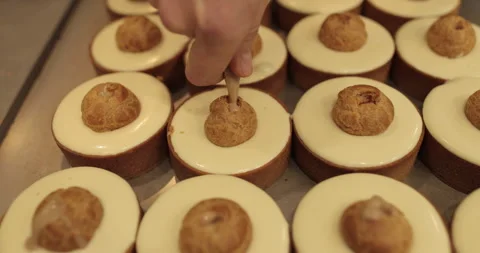 Filling small eclairs with cream using a culinary syringe Stock Footage 254814011