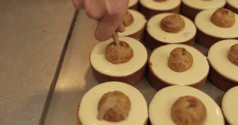 Filling small eclairs with cream using a culinary syringe Stock Footage 254814019