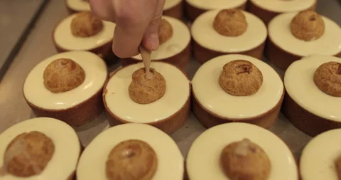 Filling small eclairs with cream using a culinary syringe Stock Footage 254814669