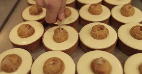 Filling small eclairs with cream using a culinary syringe Stock Footage 254814816
