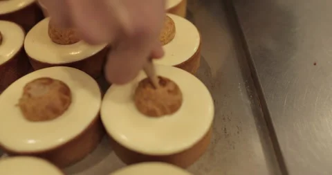 Filling small eclairs with cream using a culinary syringe Stock Footage 254814984
