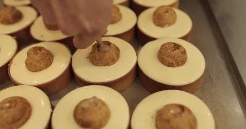 Filling small eclairs with cream using a culinary syringe Stock Footage 254815048