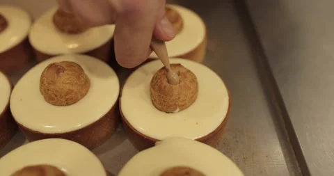 Filling small eclairs with cream using a culinary syringe Stock Footage 254815462