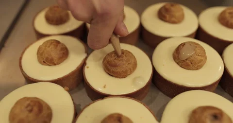 Filling small eclairs with cream using a culinary syringe Stock Footage 254815871