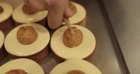 Filling small eclairs with cream using a culinary syringe Stock Footage 254816055