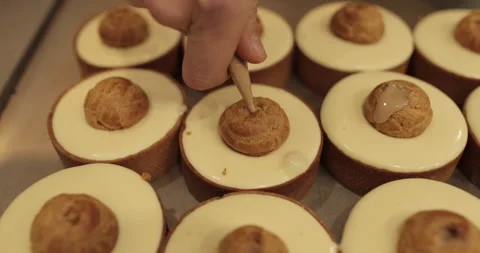 Filling small eclairs with cream using a culinary syringe Stock Footage 254816148