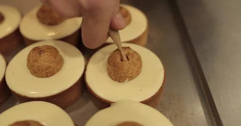 Filling small eclairs with cream using a culinary syringe on tartlets in pr.. Stock Photos