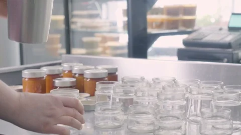 Filling small jars of homemade jam Stock Footage 129993336