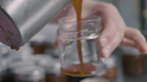 Filling small jars of homemade jam Stock Footage 129993350