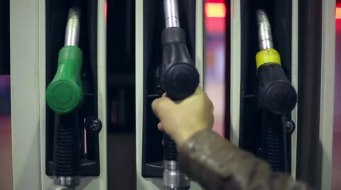 Filling station. A hand returns a fuel nozzles at a gas station at night Stock Footage 42308689