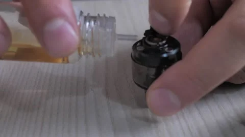 Filling the tank of an electronic cigarette with liquid Stock Footage 213041790
