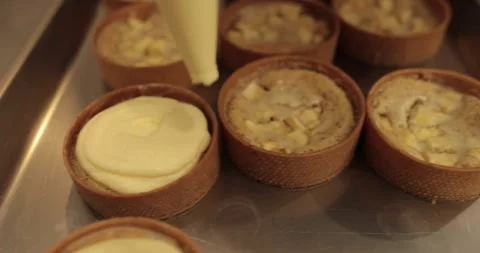 Filling tarts with cream using a piping bag. Stock Footage 255931979