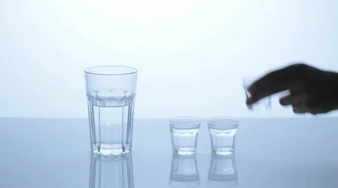 Filling three water glasses in one taller. Stock-Footage 11606355