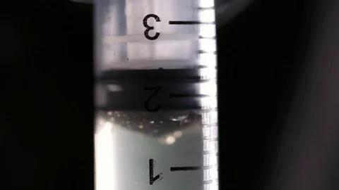 Filling us a syringe with fluid and air bubbles. Stock Footage 82877341