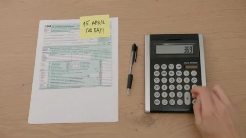 Filling US tax form papers Individual Income Tax Return calculator. closeup.. Stock Footage 272782702