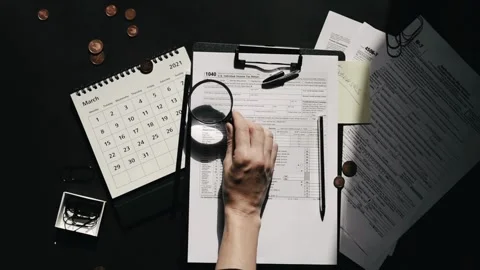 Filling US tax form papers magnifying glass Individual Income Tax Return ca.. Stock Footage 272783129