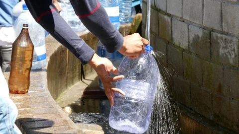 Filling water bottle at spring water tap Stock-Footage 81270367