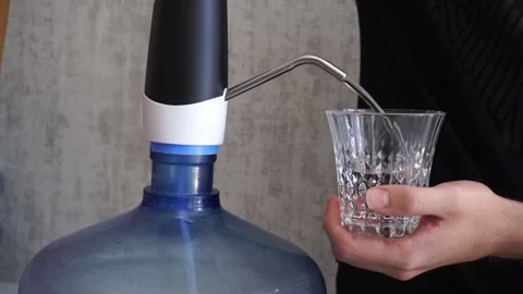 Filling water from the demijohn into a glass Stock Footage 257500577