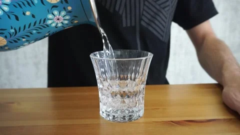 Filling water from the jug into the glass. Stock Footage 257500680