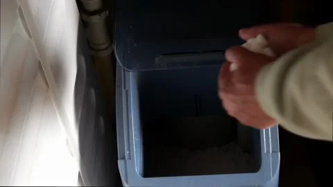 Filling a water softener with salt tablets by hand Stock Footage 270545987