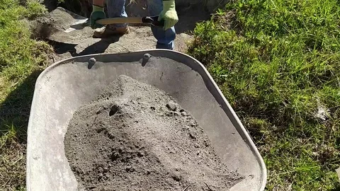 Filling a wheelbarrow with sand Stock Footage 127129196