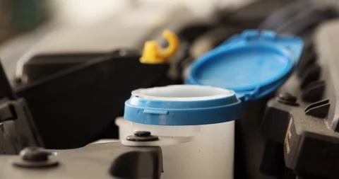Filling windshield washer fluid reservoir under the hood of a car Stock Footage 345980855