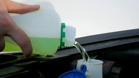 Filling up a windshield washer tank of a car by antifreeze close up Stock Footage 130130181