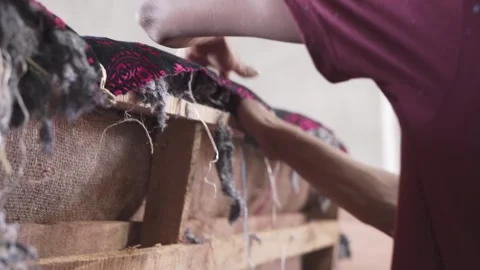 Filling wooden structure of a couch sofa with synthetic cotton by an Stock Footage 242982578