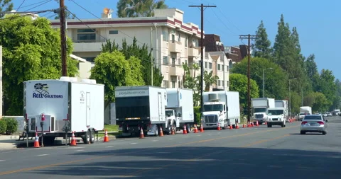 Film crew and movie transport production trucks behind the scenes in Los Angeles Stock Footage 213648890