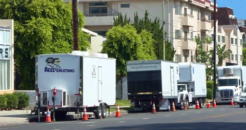 Film crew and movie transport production trucks behind the scenes in Los Angeles Stock Footage 213651742