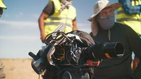 Film crew protecting the movie camera from a sandstorm Stock Footage 221915686