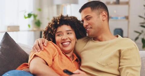 Film, love and entertainment with a couple watching tv on a sofa in the living Stock Photos
